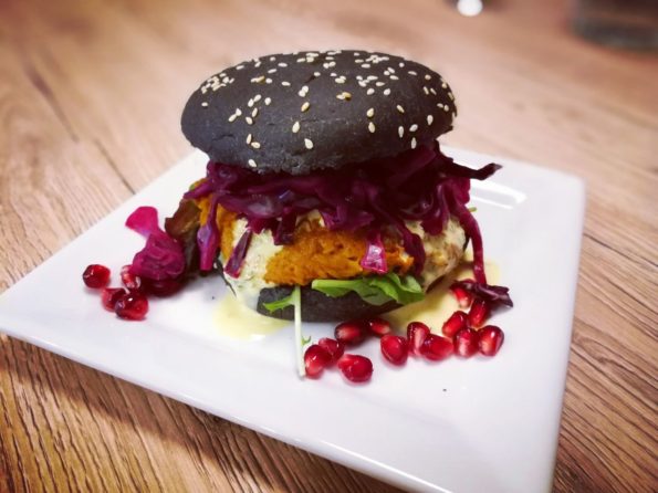 Veganer Burger mit Kürbis-Hummus Patty, Curry-Salbei Relish und Blaukraut-Granatapfel Topping